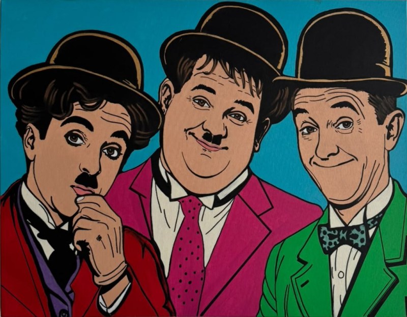 Portrait en buste de Charlie Chaplin, Oliver Hardy et Stan Laurel peints dans un style pop art coloré sur fond bleu.